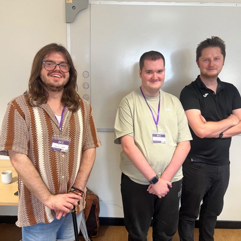 3 people stood in front of white board.
